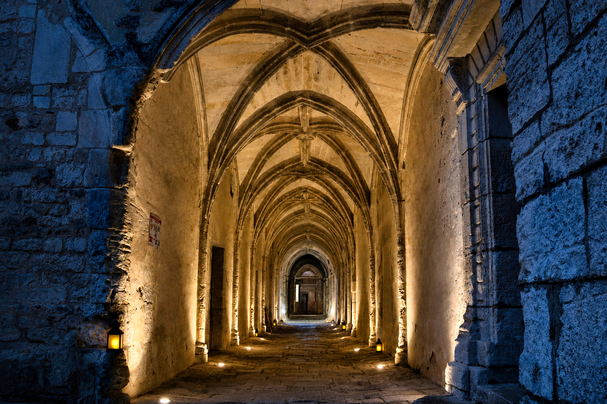 Galerie voûtée de l'abbaye éclairée en bleu et or