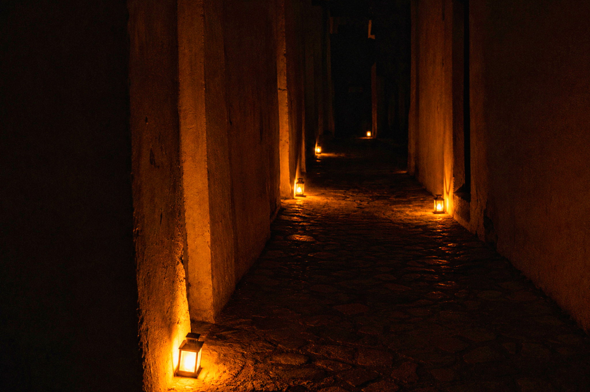 Couloir de l'abbaye de Bassac éclairé par des lanternes