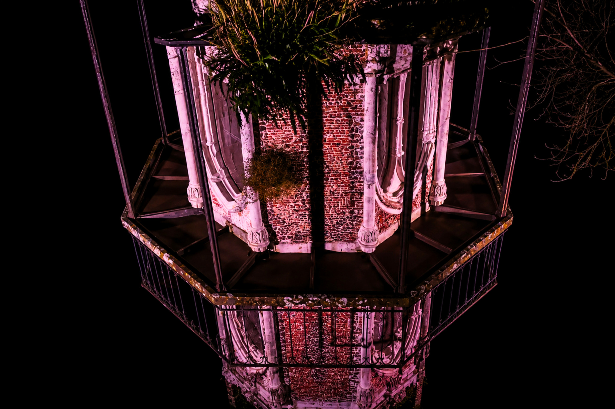 Sommet de la tour gothique du jardin public de Cognac éclairé en rose