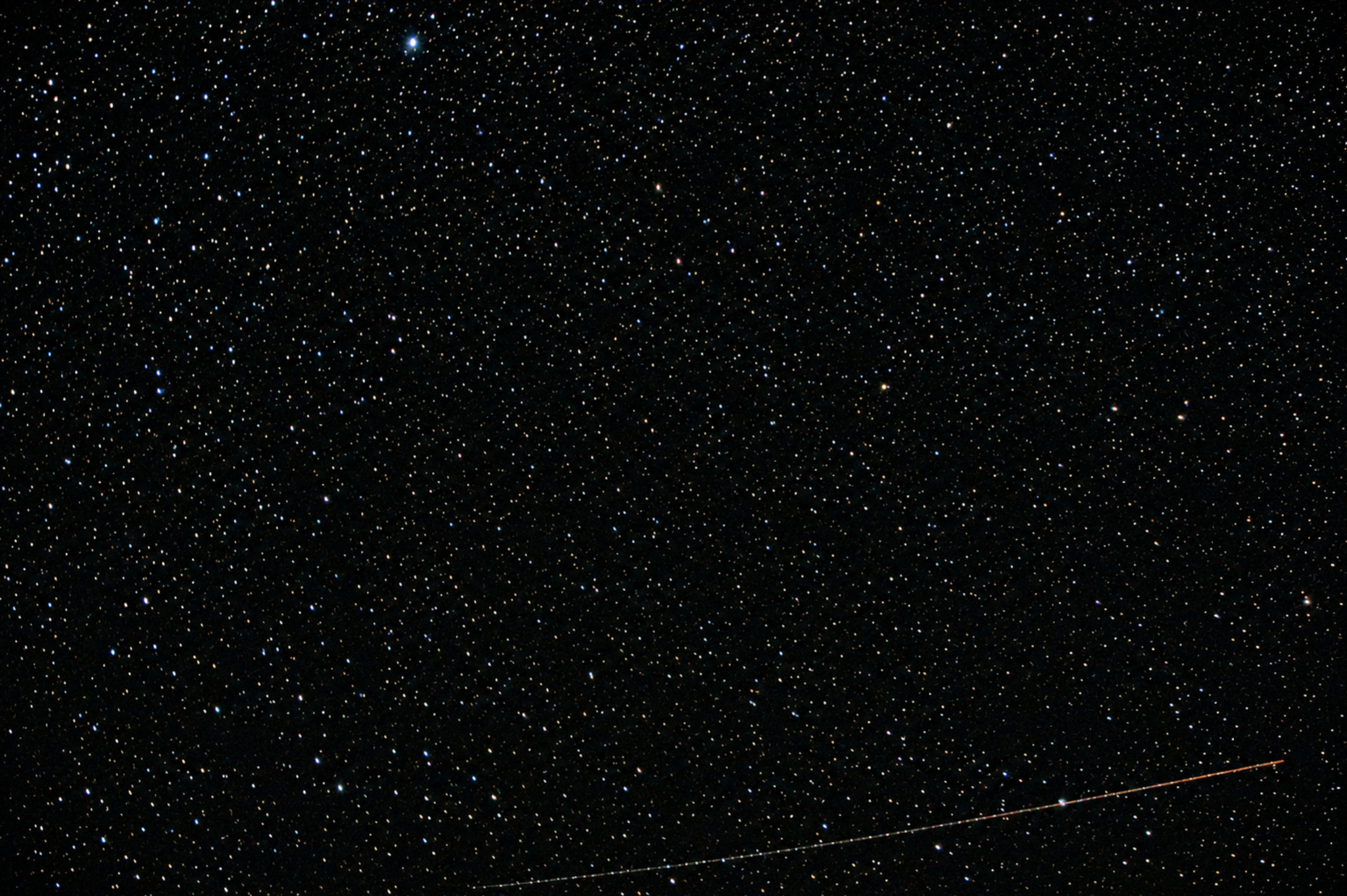 Champ d'étoiles traversé par une trace lumineuse